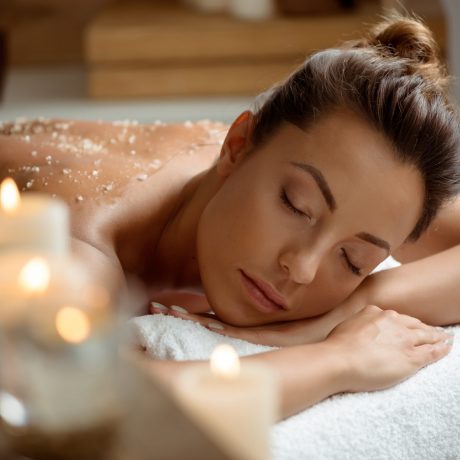 Young beautiful brunette girl relaxing in spa salon. Copy space. Eyes closed.